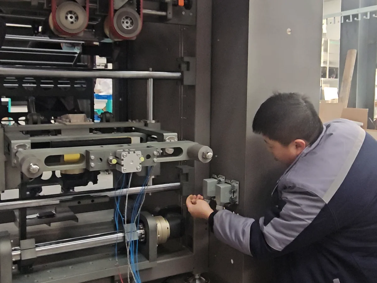 A technician working on the drive assembly of a VFFS packaging machine.