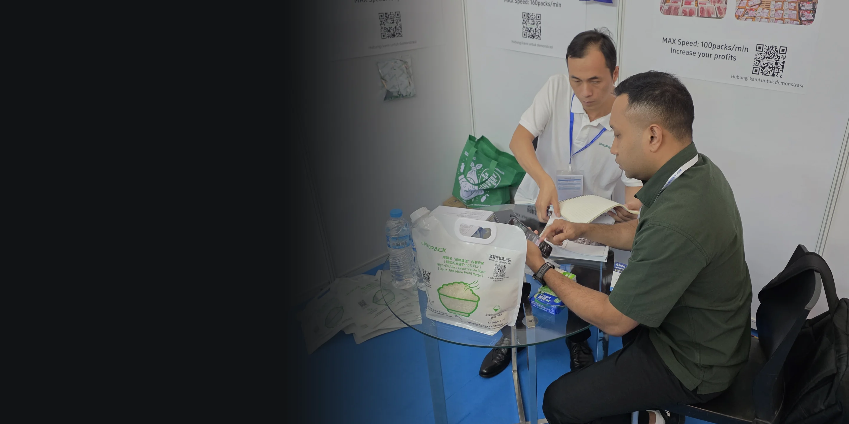 A LINYOPACK engineer reviewing a pouch sample with a visitor