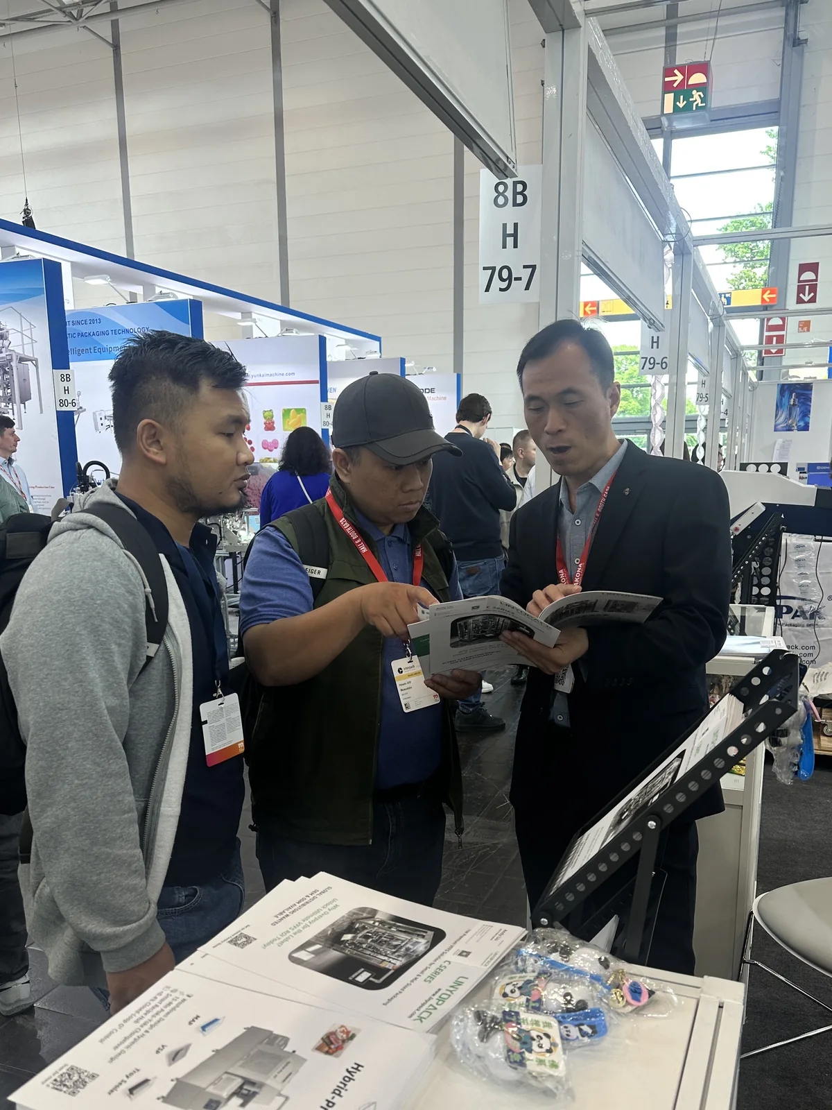 Visitors at stand H79-7 looking at a brochure with our team