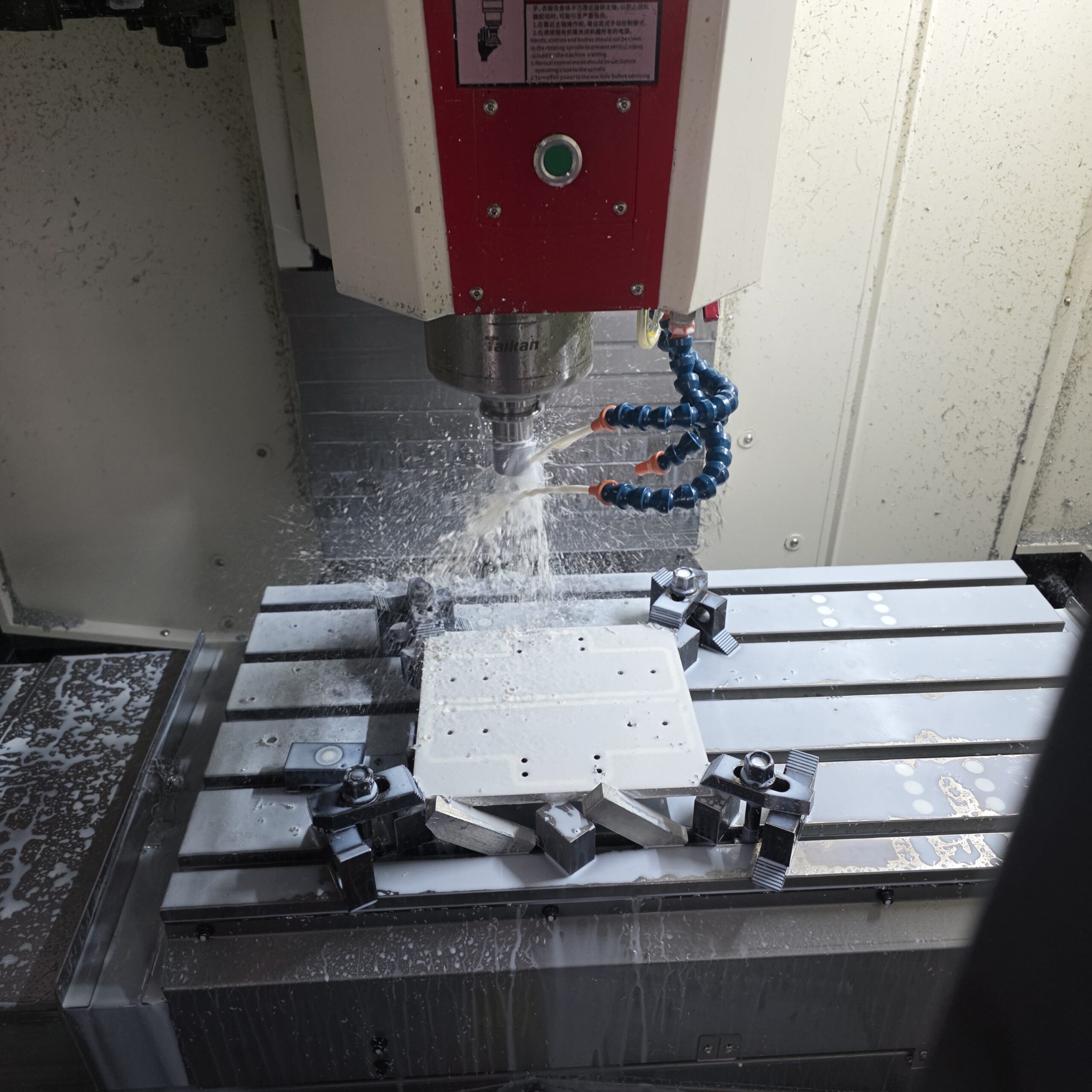 CNC spindle machining a clamped metal workpiece.