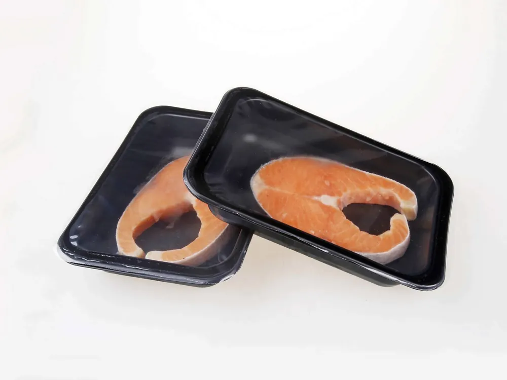 Salmon steaks in sealed black trays